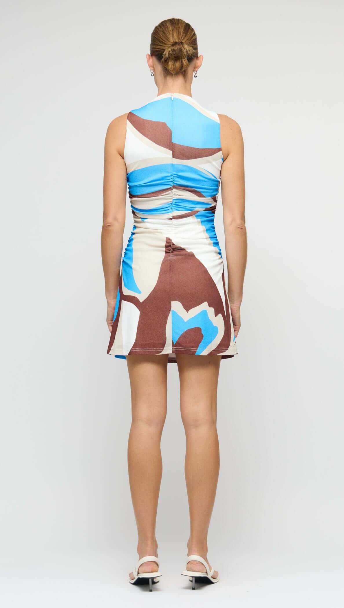 Back view of the Blue Abstract Mesh Mini Dress showcasing its ruched waist and bold abstract print.