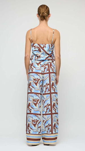 Back view of a woman wearing a Blue Abstract floral Scarf Cami Top with wide-leg pants, showcasing a summer outfit.
