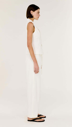 Model showcasing the White Cotton Relaxed Wide-Leg Pant with a sleeveless top in a side view, emphasizing comfort and style.