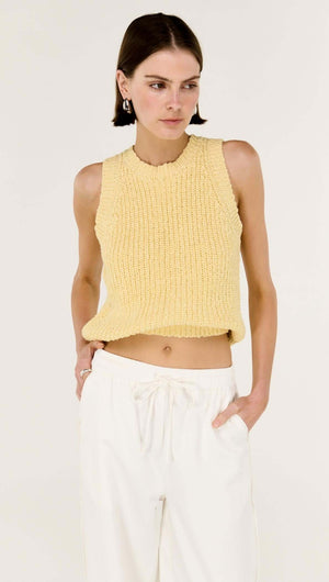 Model wearing a yellow knit sleeveless top paired with white cotton relaxed wide-leg pant.