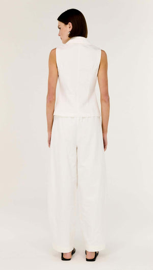 Back view of a model wearing a White Cotton Tailored Vest Top and wide-leg trousers in a stylish, minimalist outfit.