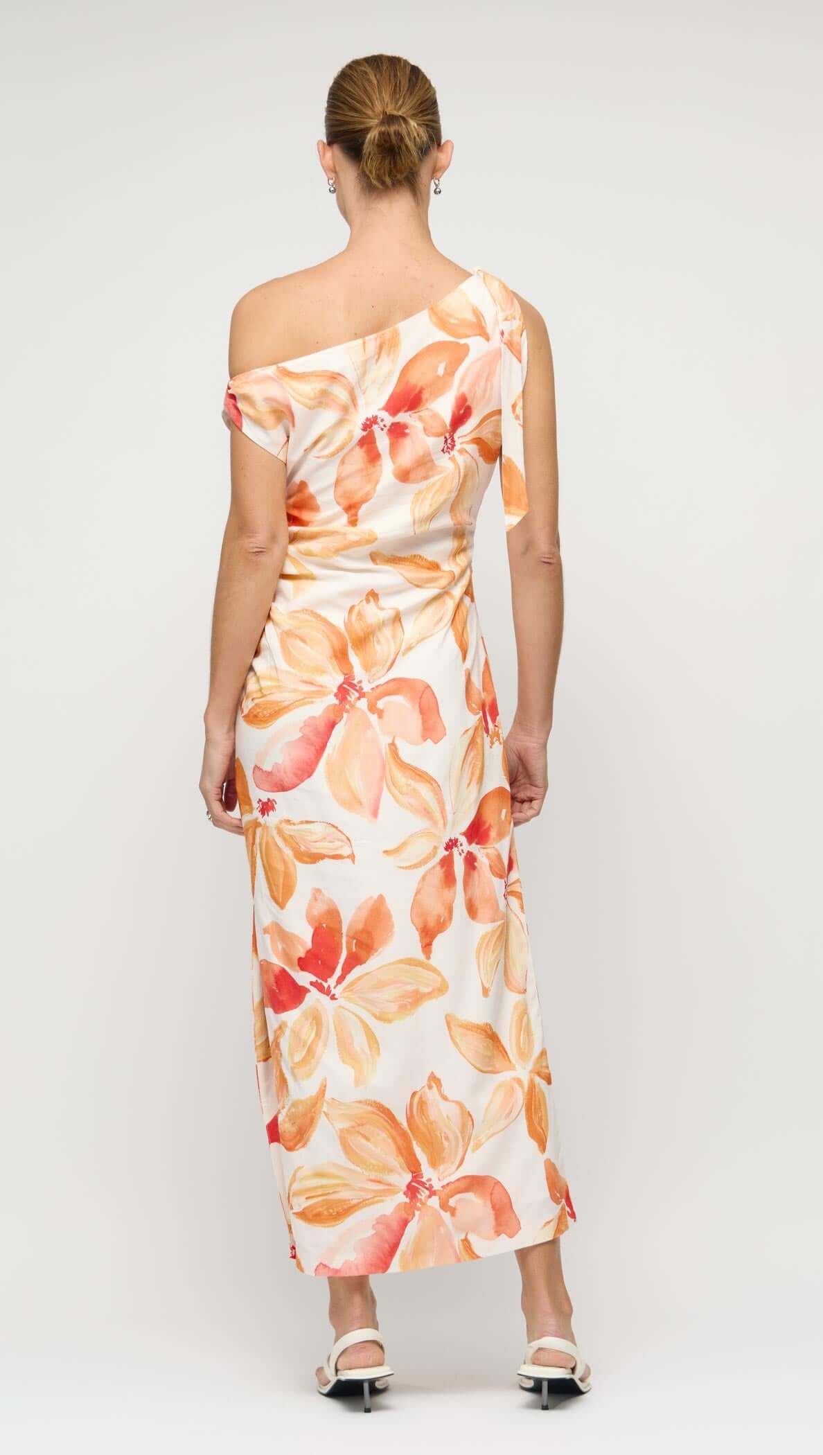 Back view of the stylish Orange & White Floral Asymmetric Midi Dress featuring a one-shoulder neckline and beautiful floral print.