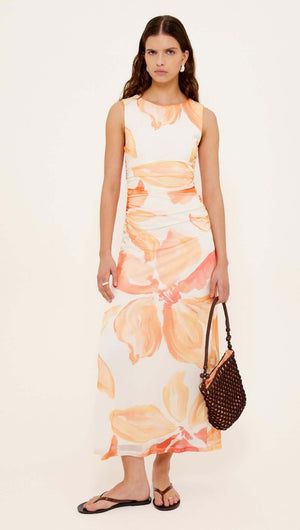 Model wearing the Orange & White Floral Mesh Midi Dress with abstract floral print and side ruching, accessorized with a handbag.