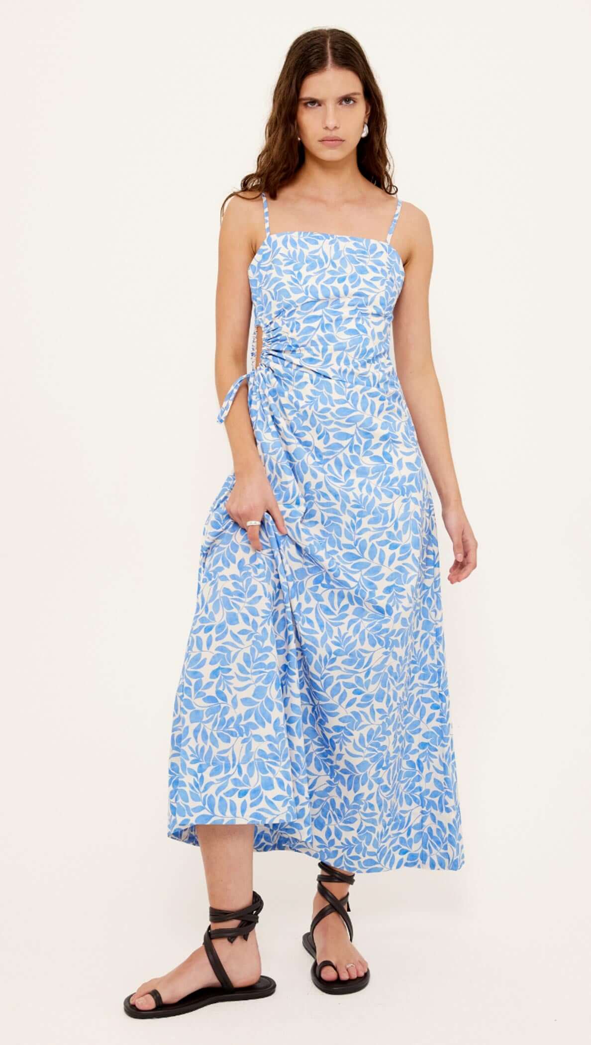 Cotton Blue Leaf Print Cut Out Maxi Dress featuring a blue and ivory leaf print with ruched waist and adjustable straps.