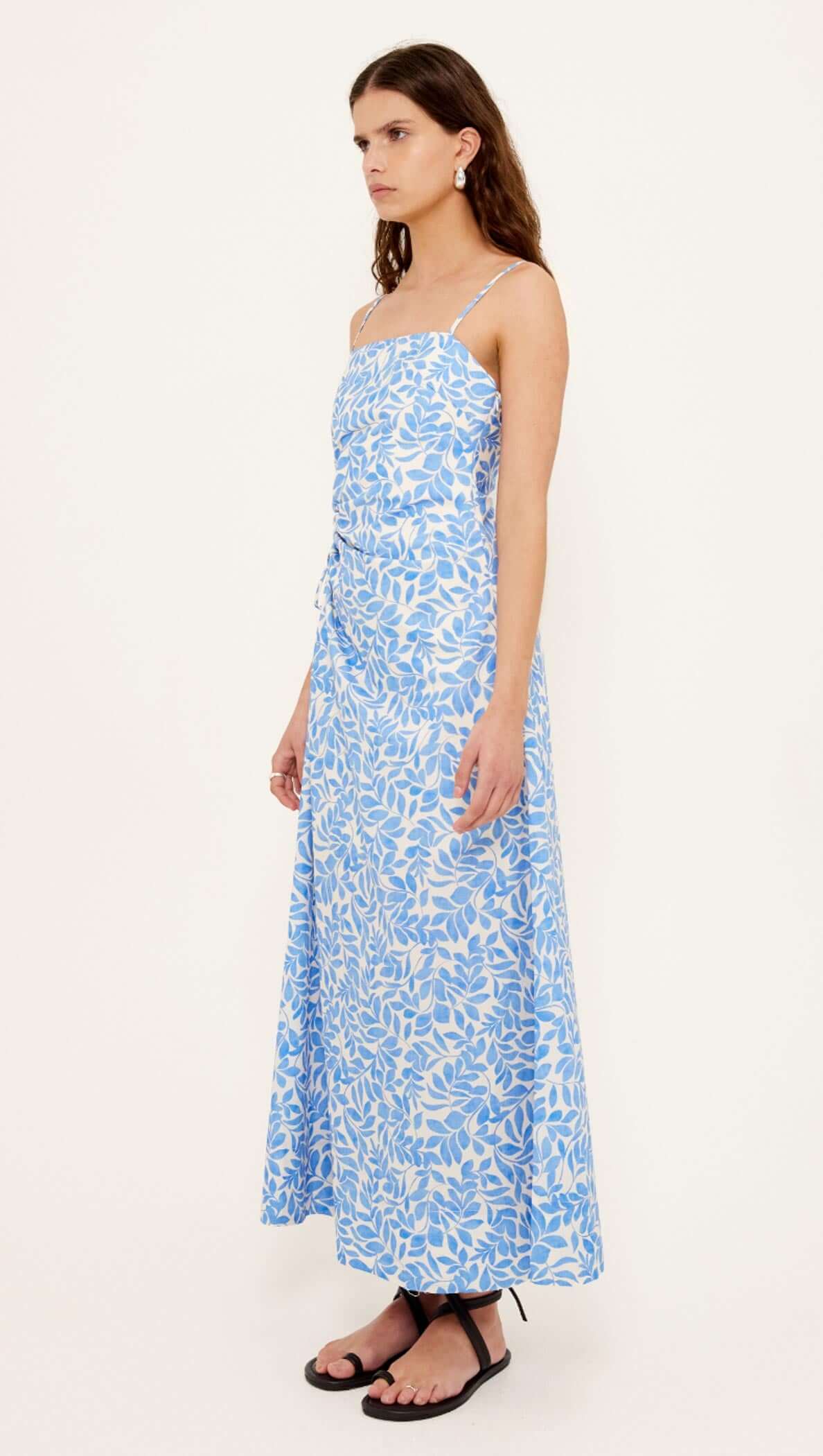 Cotton Blue Leaf Print Cut Out Maxi Dress shown on model in blue leaf print fabric with adjustable straps.
