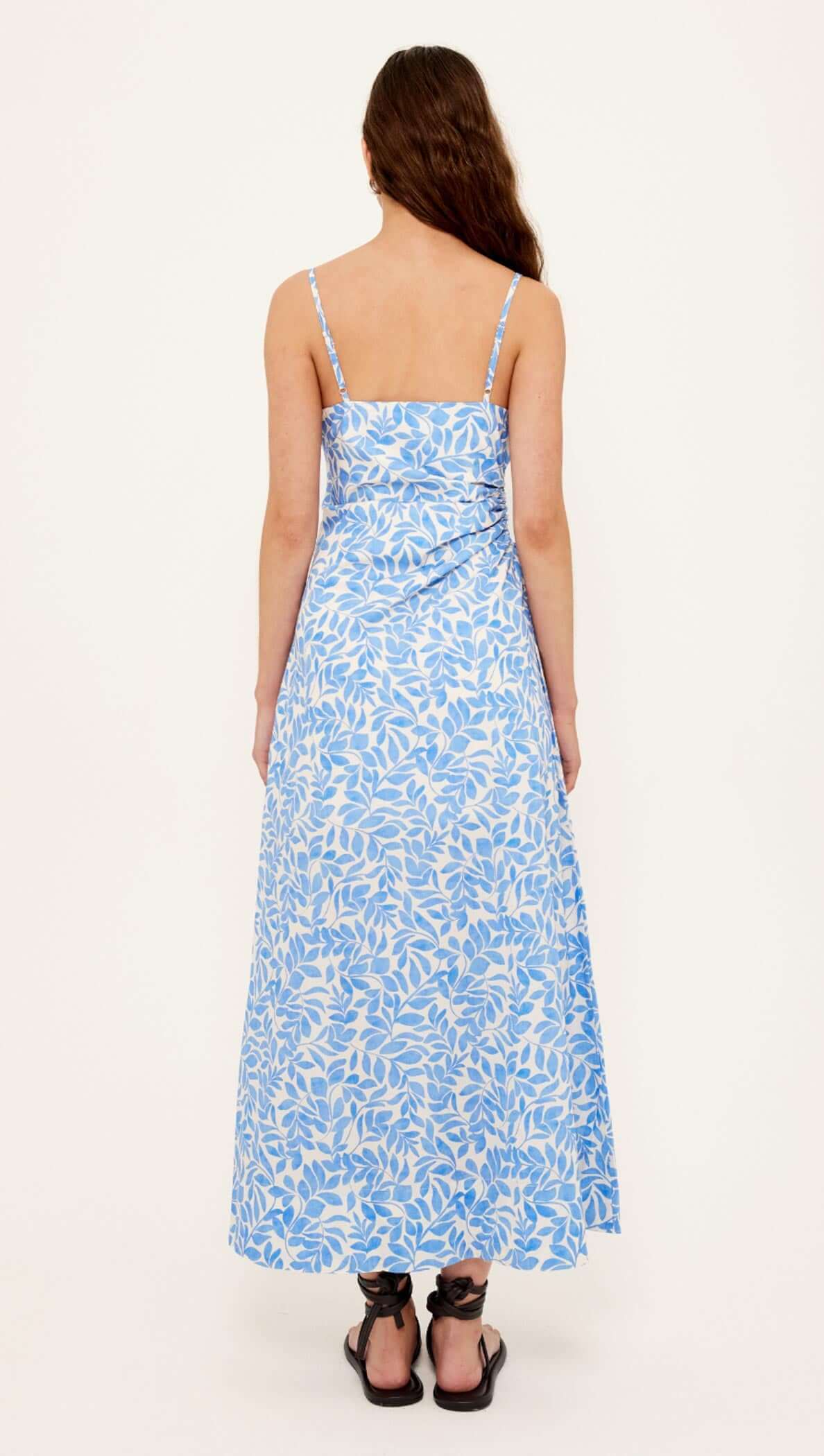 Cotton Blue Leaf Print Cut Out Maxi Dress shown from the back, featuring adjustable straps and a flared maxi skirt.