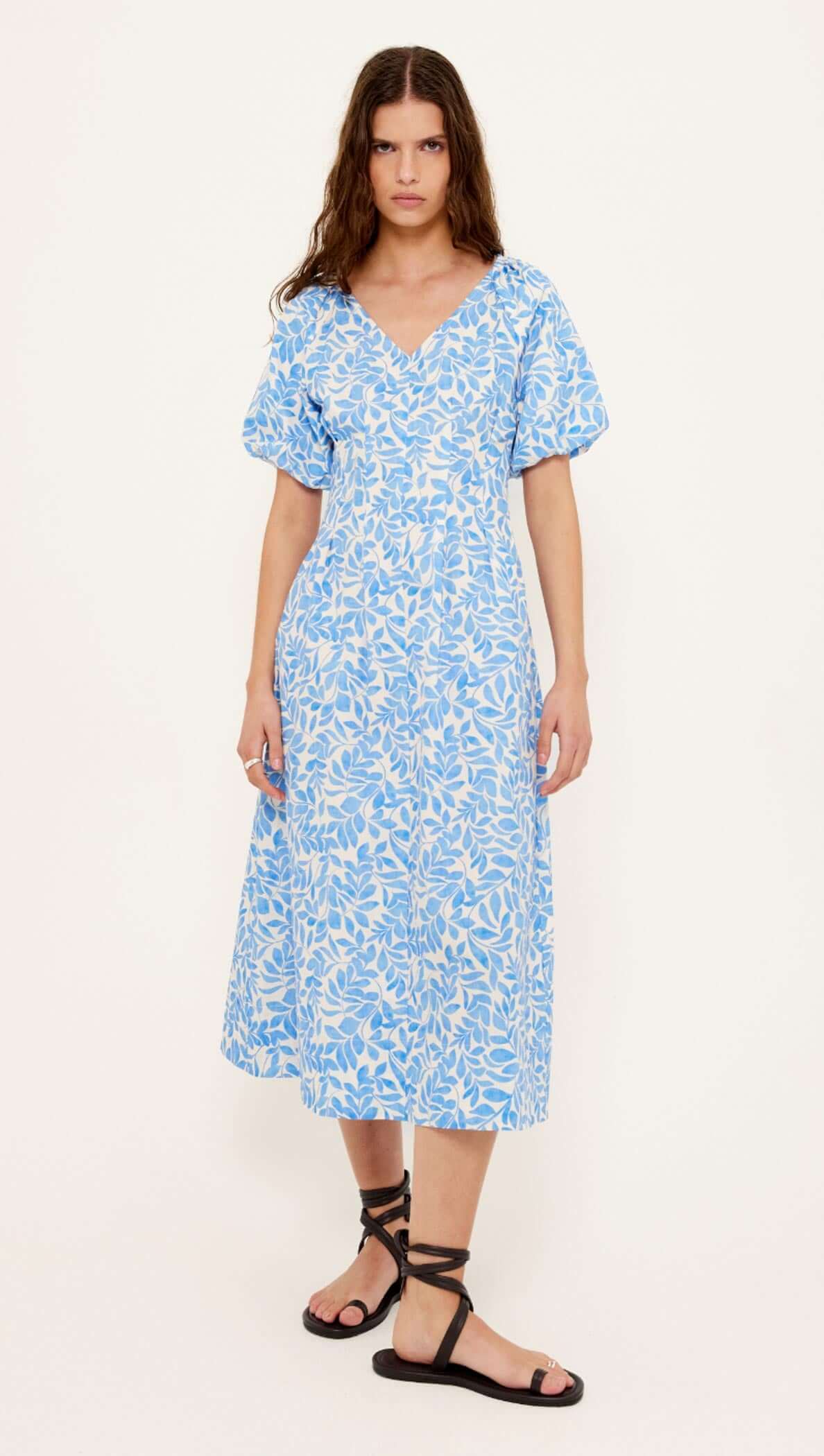 Cotton Blue Leaf Print V-neck Midi Dress model wearing blue and ivory leaf print dress with puff sleeves