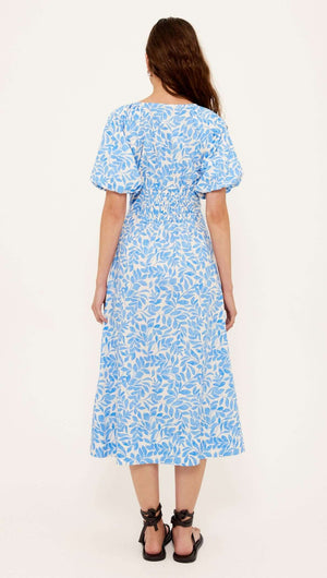 Back view of the Solea Cotton Blue Leaf Print V-neck Midi Dress showcasing the blue and ivory leaf pattern.