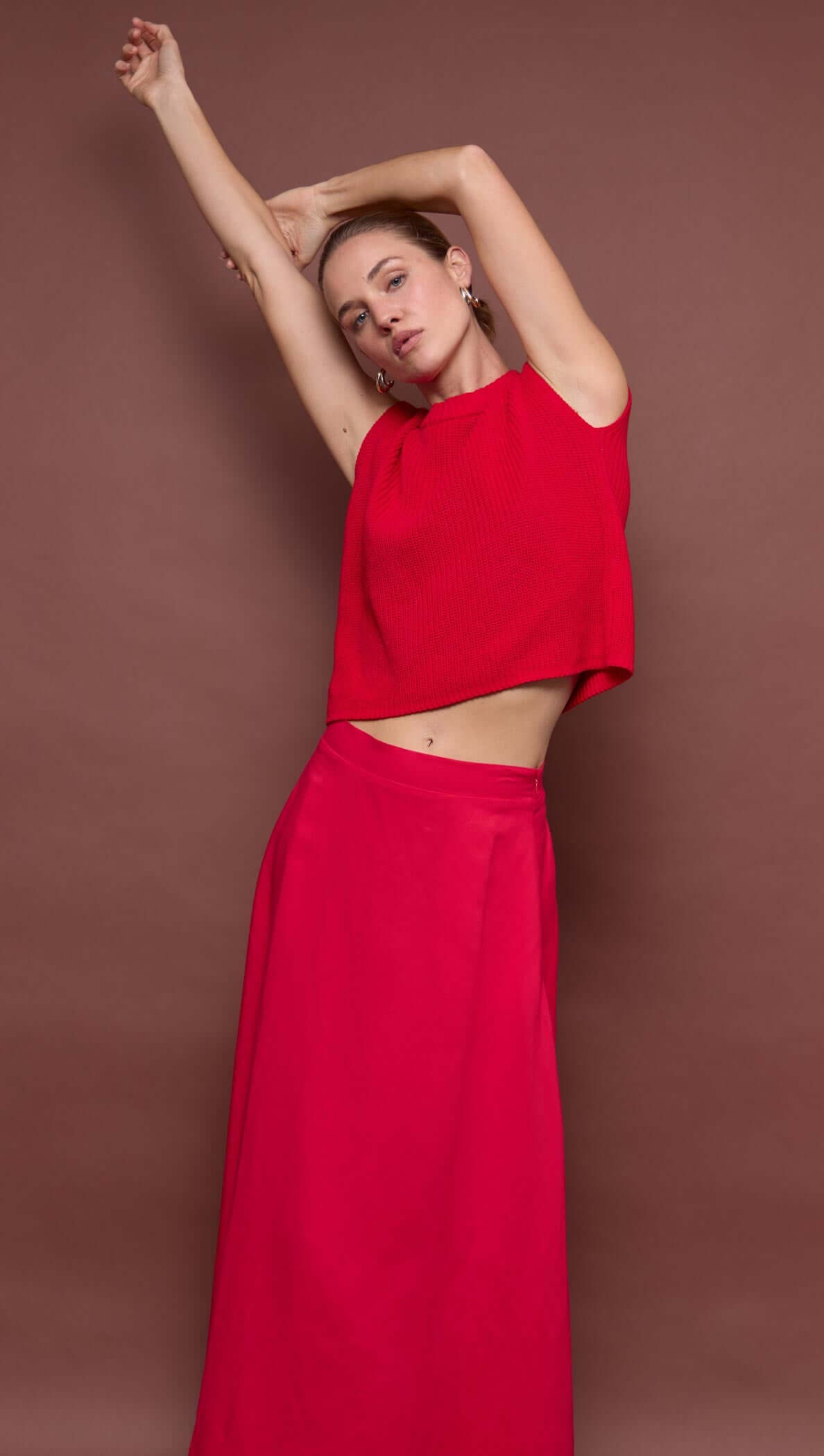 Model wearing a stylish Red Linen Blend Maxi Skirt paired with a matching top against a brown background.