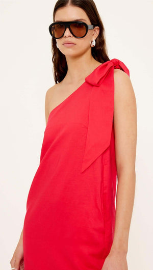Close-up of a model wearing the Red Linen Blend One Shoulder Mini Dress with oversized shoulder tie.