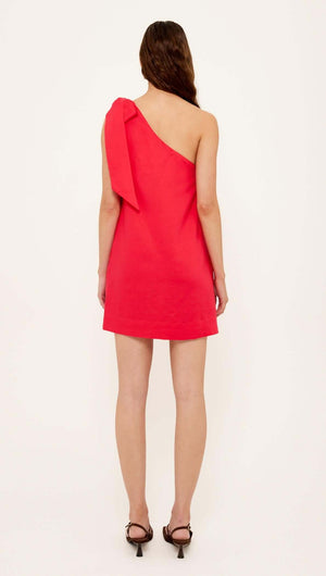 Back view of a woman wearing a Red Linen Blend One Shoulder Mini Dress with an oversized shoulder tie.