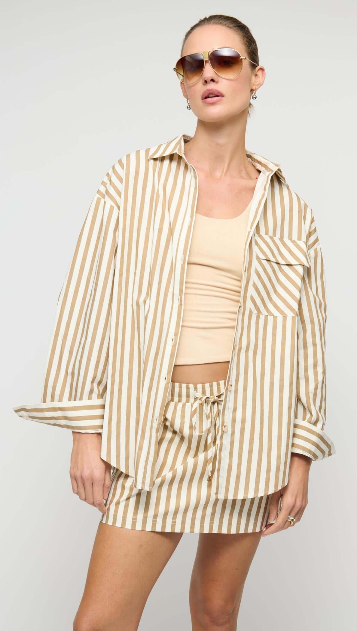 Model wearing Cotton Oversized Stripe Shirt paired with matching skirt, showcasing a relaxed and stylish look.