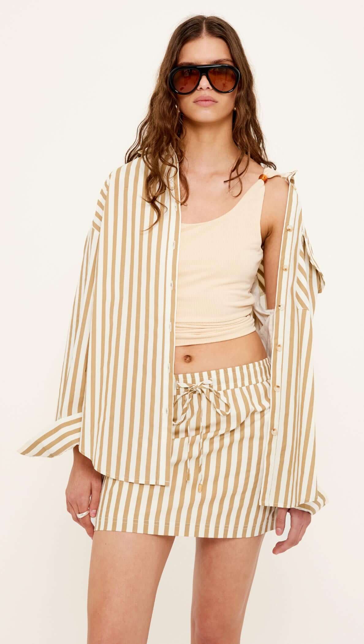 Model wearing a Cotton Oversized Stripe Shirt with matching skirt, showcasing a relaxed and stylish look.