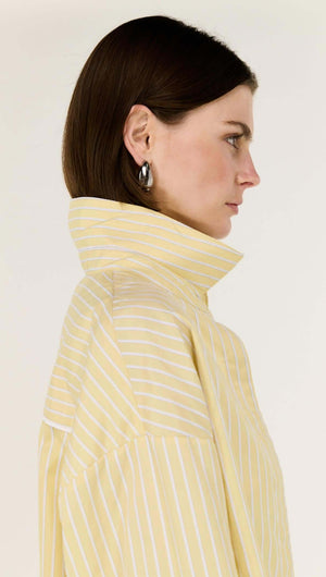 Model wearing a Butter Yellow Striped Shirt featuring a classic collar and relaxed fit, highlighting stripe detailing.