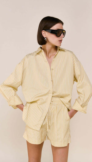 Model wearing a Butter Yellow Striped Shirt paired with matching shorts, showcasing a relaxed and stylish look.