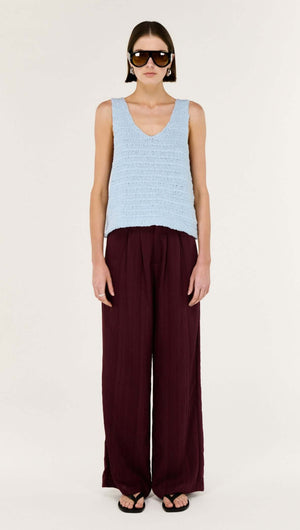 Model wearing a Baby Blue Cotton Knit Tank with a V neckline paired with wide-leg maroon pants.