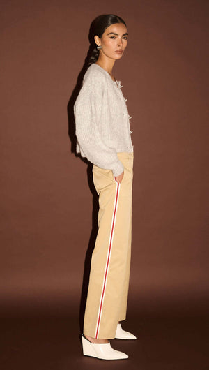 Model wearing Beige Striped Contrast Waist Pants styled with a grey sweater against a brown backdrop.