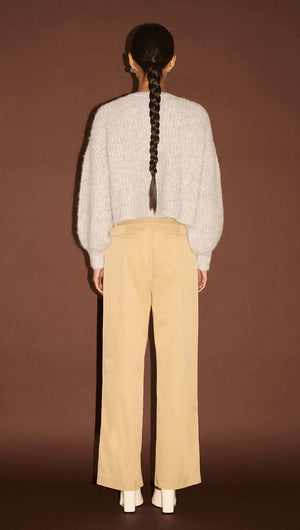 Back view of a model wearing Beige Striped Contrast Waist Pants paired with a cozy gray sweater.