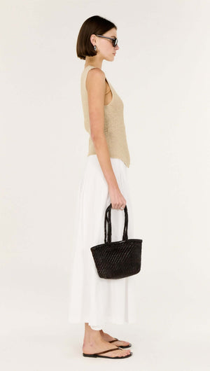 Model wearing the Beige V-neck Wrap Knit Top paired with a white skirt and holding a black handbag.