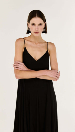 Model wearing a Black V-Neck Floaty Maxi Dress with fine shoulder straps, showcasing elegant silhouette.