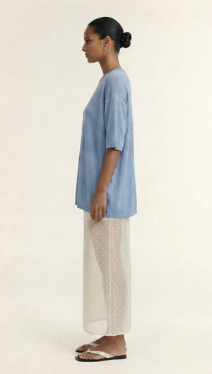 Model wearing Blue Round Neck Oversized Knit Tee with relaxed fit and dropped shoulders, paired with sheer polka dot skirt.