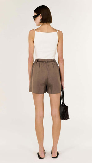 Model wearing Brown Linen Blend High Waisted Shorts with a white top and black accessories, showcasing a relaxed silhouette.