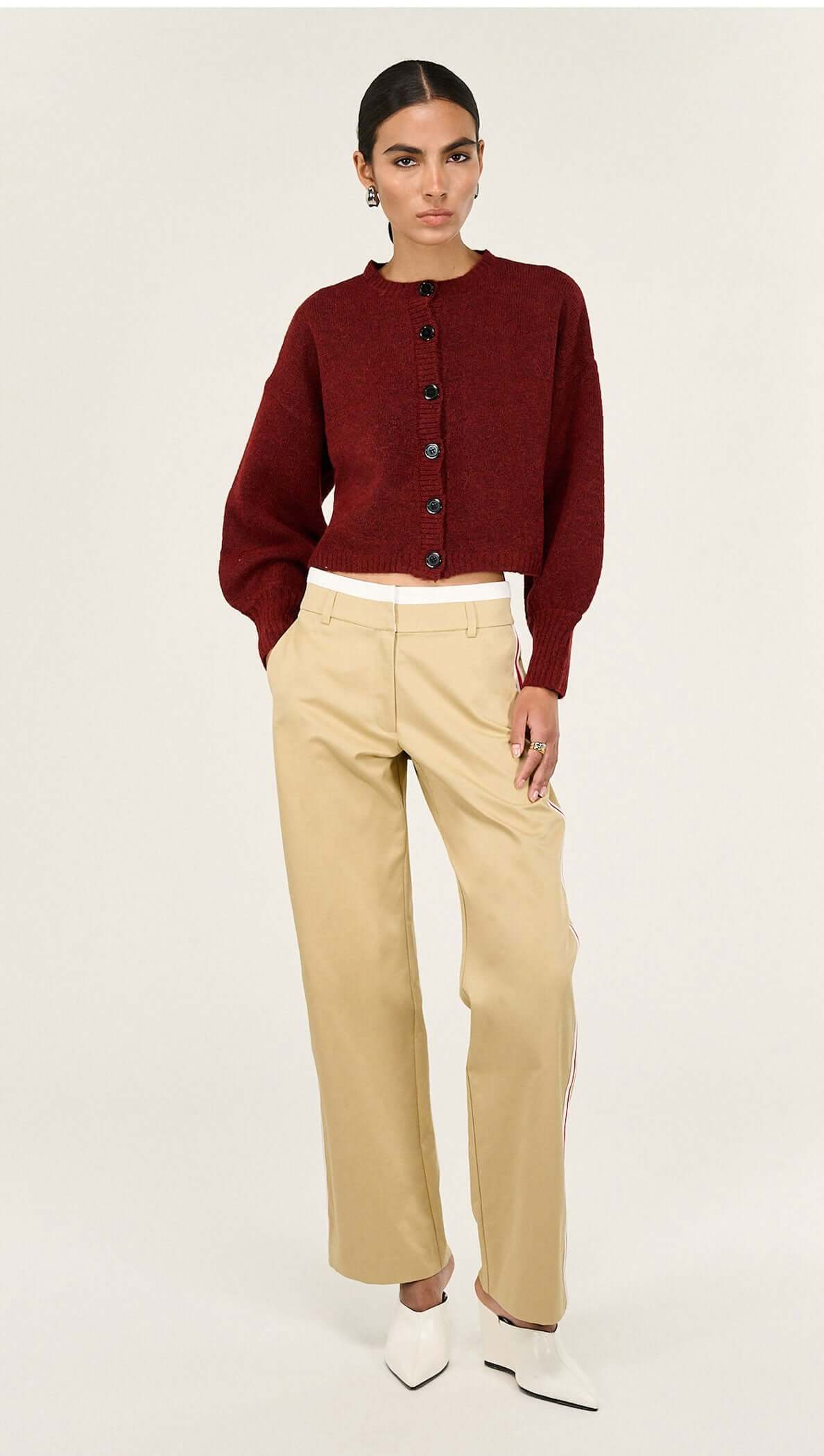 Burgundy Cropped Knit Cardigan styled with high-waisted beige trousers, featuring balloon sleeves and button detailing.