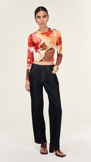 Model wearing the Burnt Floral Long Sleeve Mesh Top paired with dark wide-leg jeans.