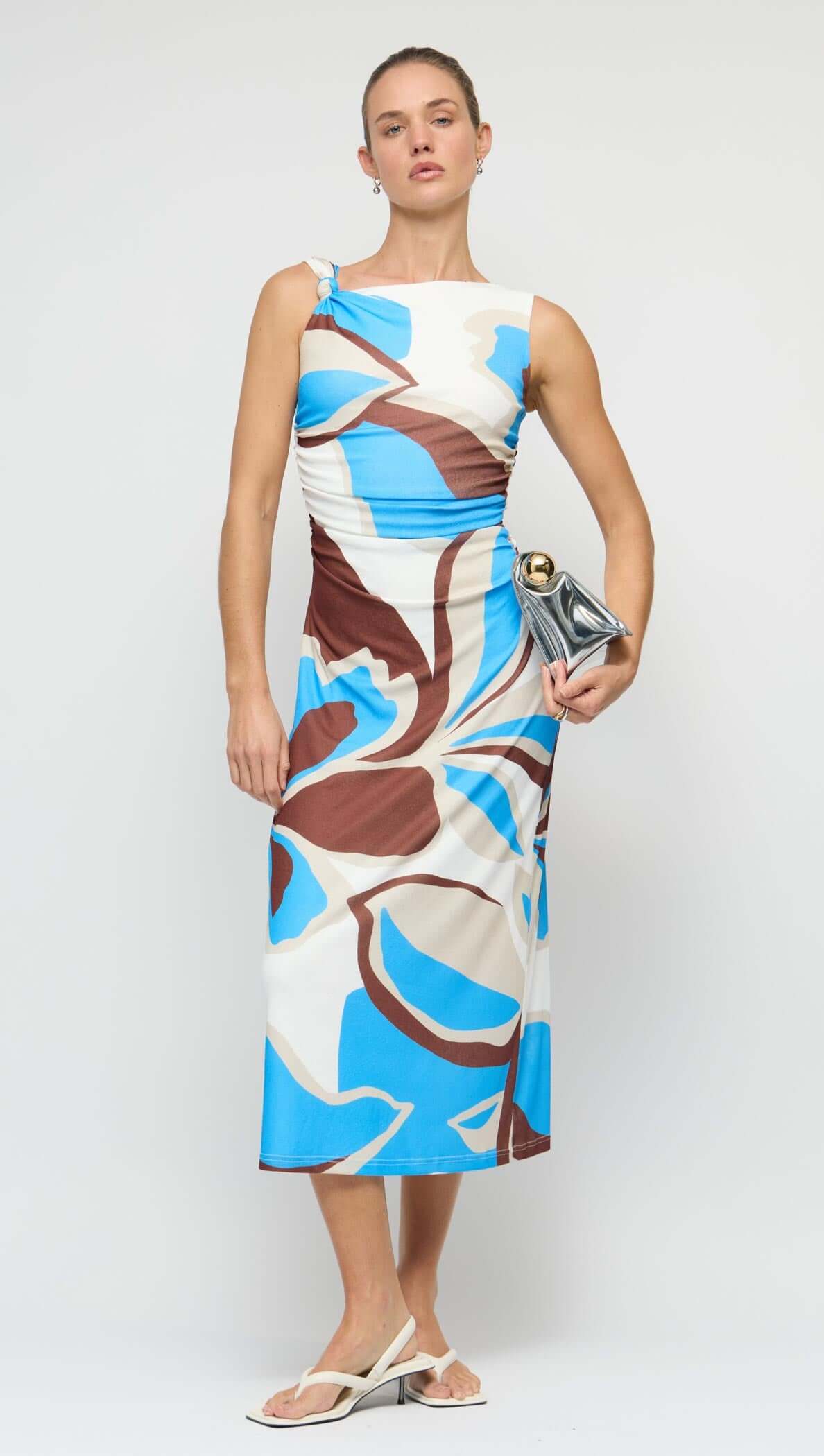 Model wearing a Blue Abstract Mesh Midi Dress featuring an asymmetric shoulder and abstract print in blue and brown.