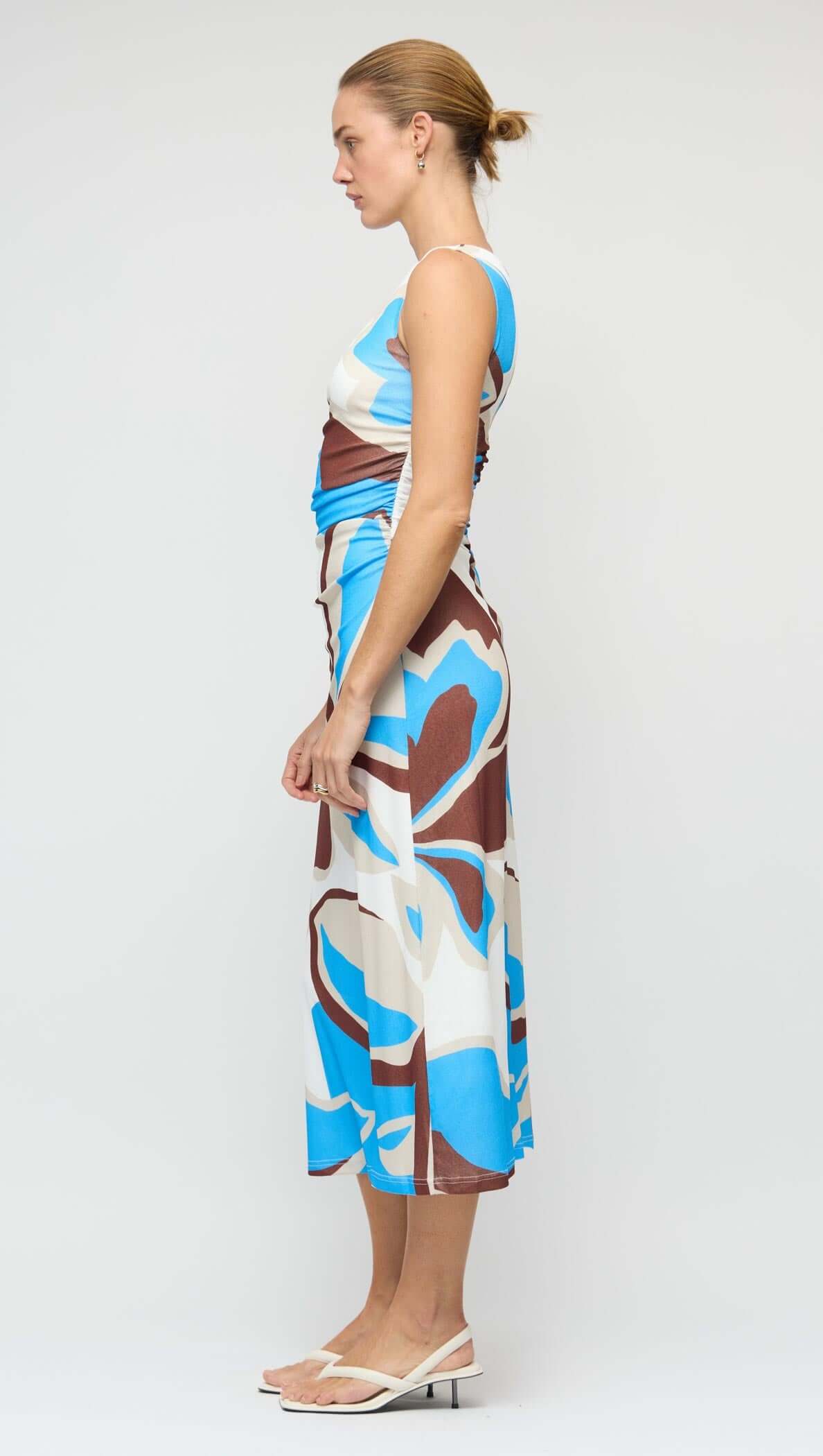 Side view of a woman wearing a Blue Abstract Mesh Midi Dress with an asymmetric shoulder and unique print.
