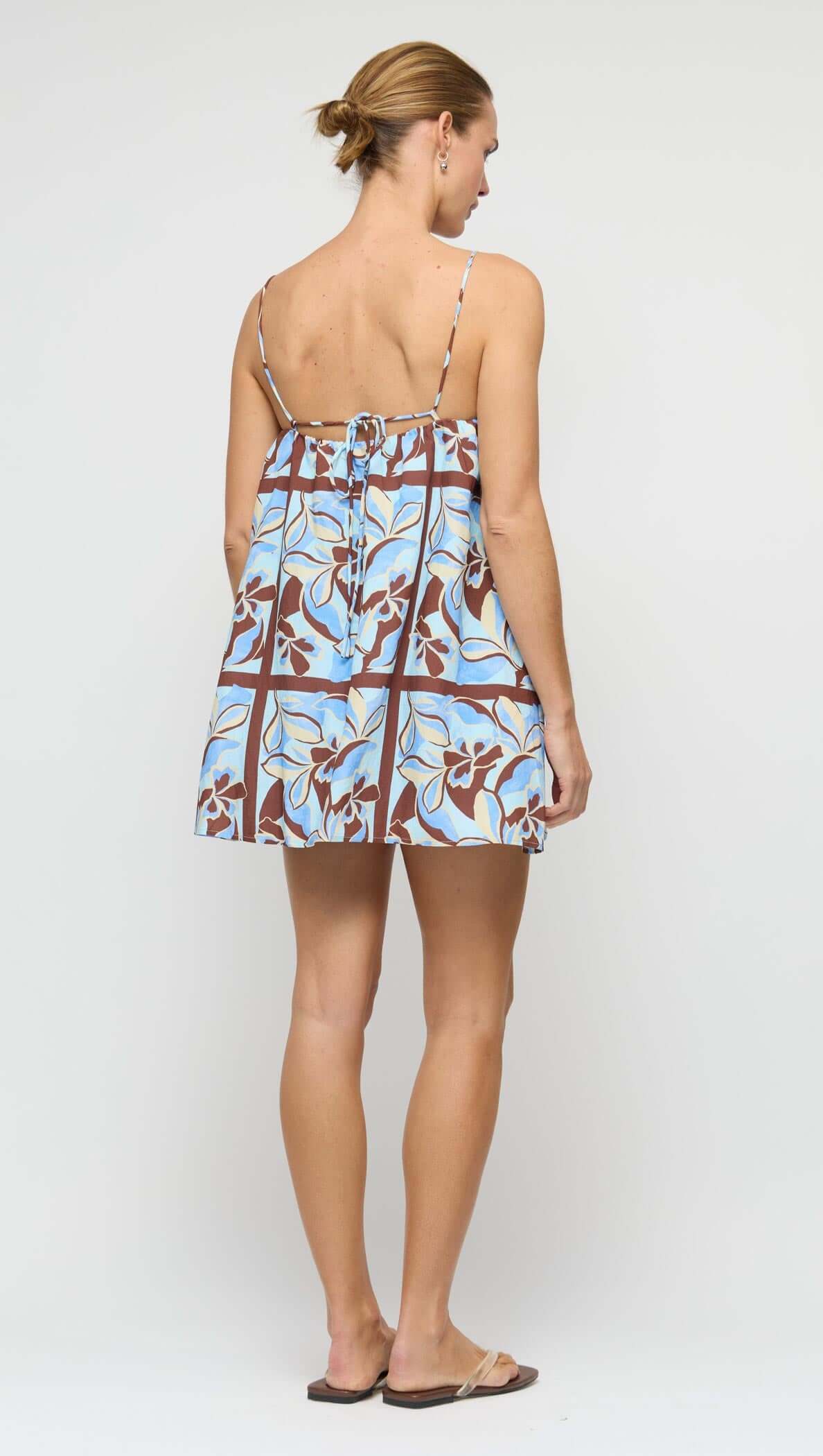 Blue Abstract floral Mini Dress showing back view on a model with a natural setting.