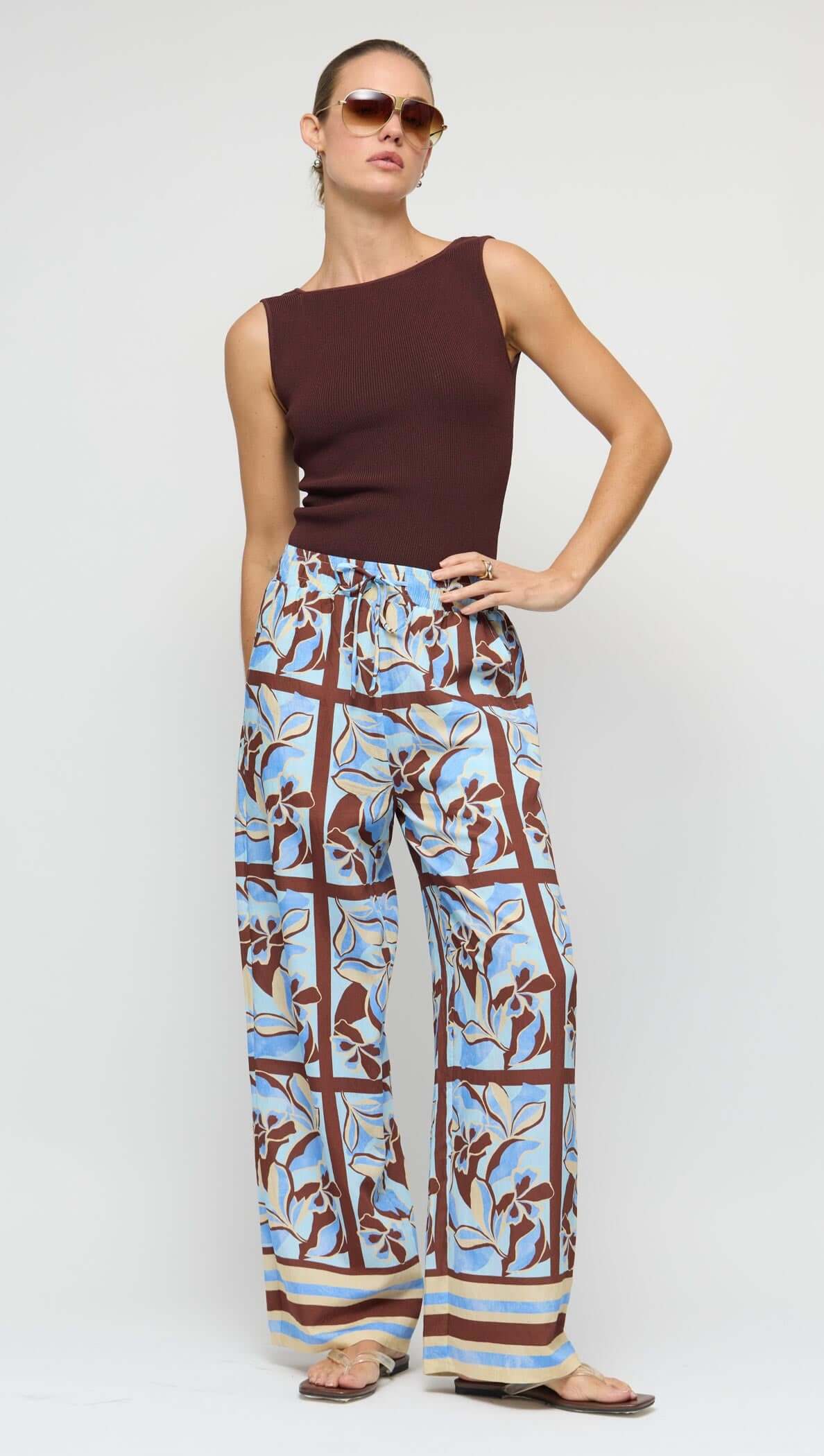 Blue Abstract floral Wide-Leg Drawstring Pants worn by a model with a wooden chair in the background.