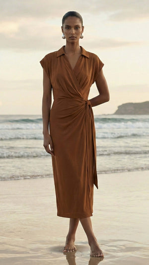 Model wearing a Copper Draped Wrap Midi Dress on the beach, showcasing the elegant fabric and relaxed fit.