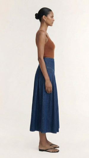 Model showcasing the Copper Square Neck Ribbed Knit Tank paired with a denim skirt from a side profile.