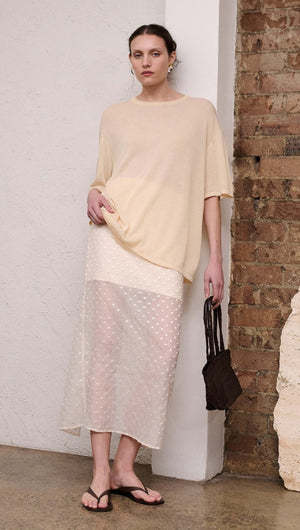 Cream Embroidered Spot Sheer Layered Midi Skirt styled with a loose top in a modern interior setting.