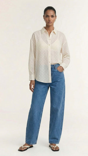Fashion model wearing a Cream Embroidered Spot Sheer Oversized Shirt with denim jeans and sandals.