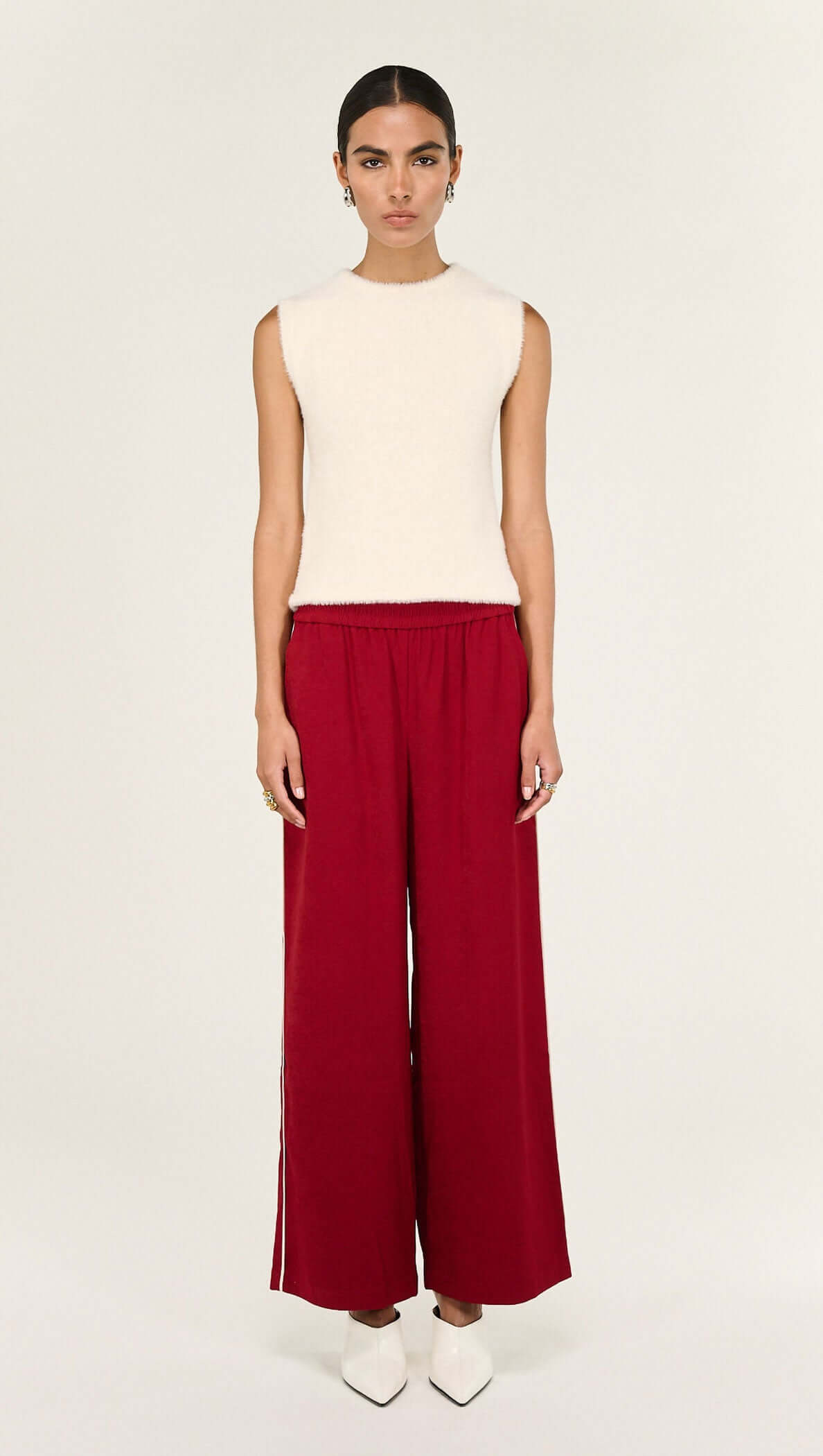 Model wearing the Cream Fluffy Knit Tank paired with red pants, showcasing its soft texture and sleeveless design.