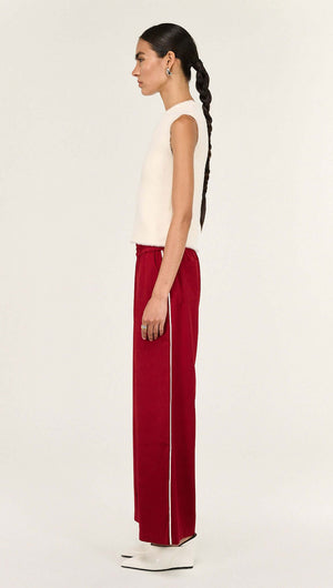 Model showcasing the Cream Fluffy Knit Tank paired with red wide-leg pants, highlighting relaxed yet stylish apparel.