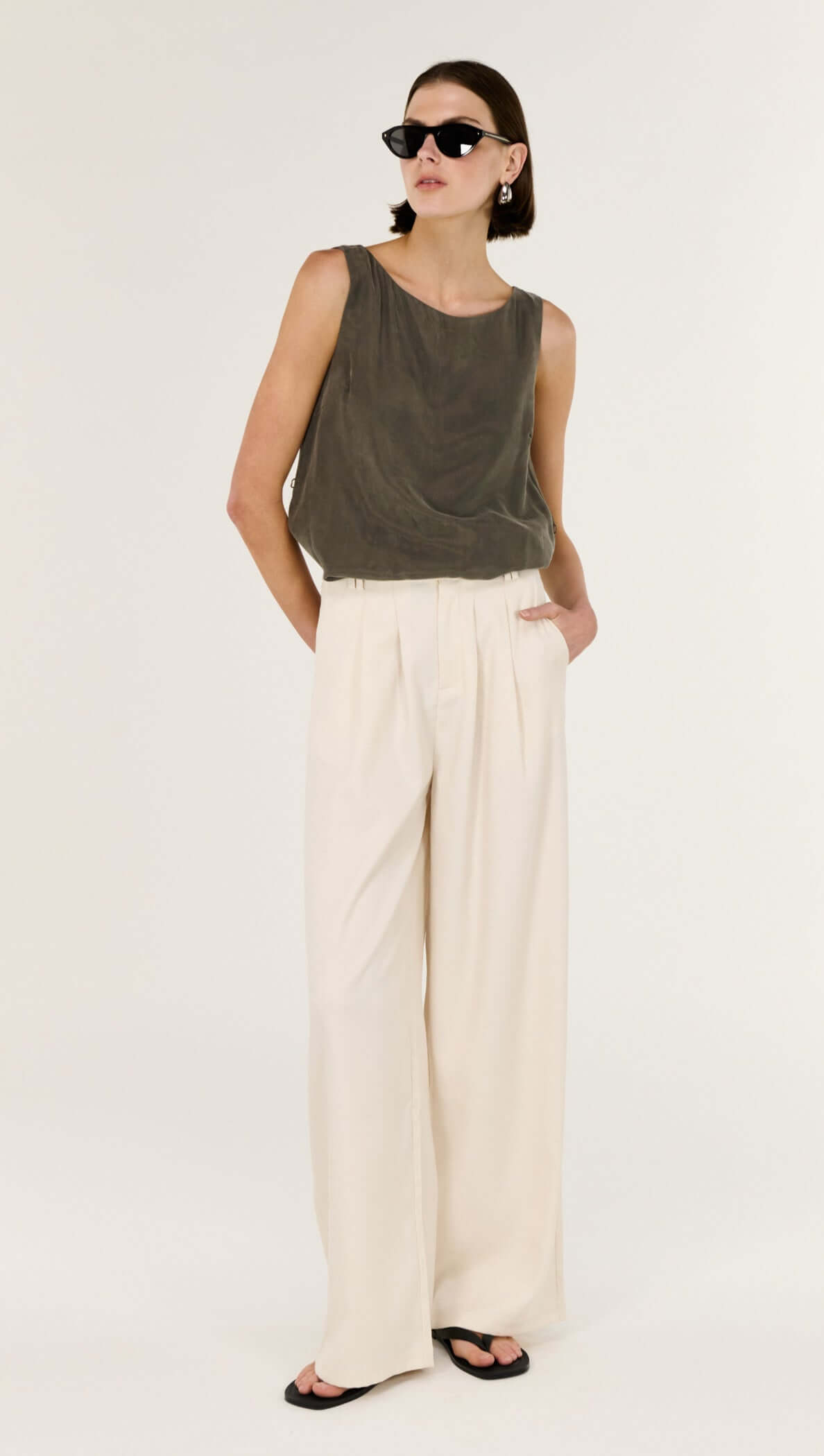 Model wearing Cream High Waisted Drape Pant paired with a stylish tank and sunglasses.