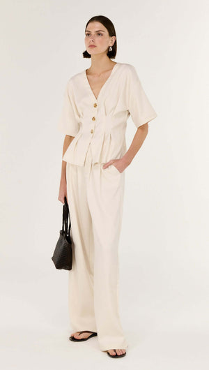 Model showcasing the Cream Pintuck Button Front Top paired with stylish pants, emphasizing contemporary fashion and elegance.