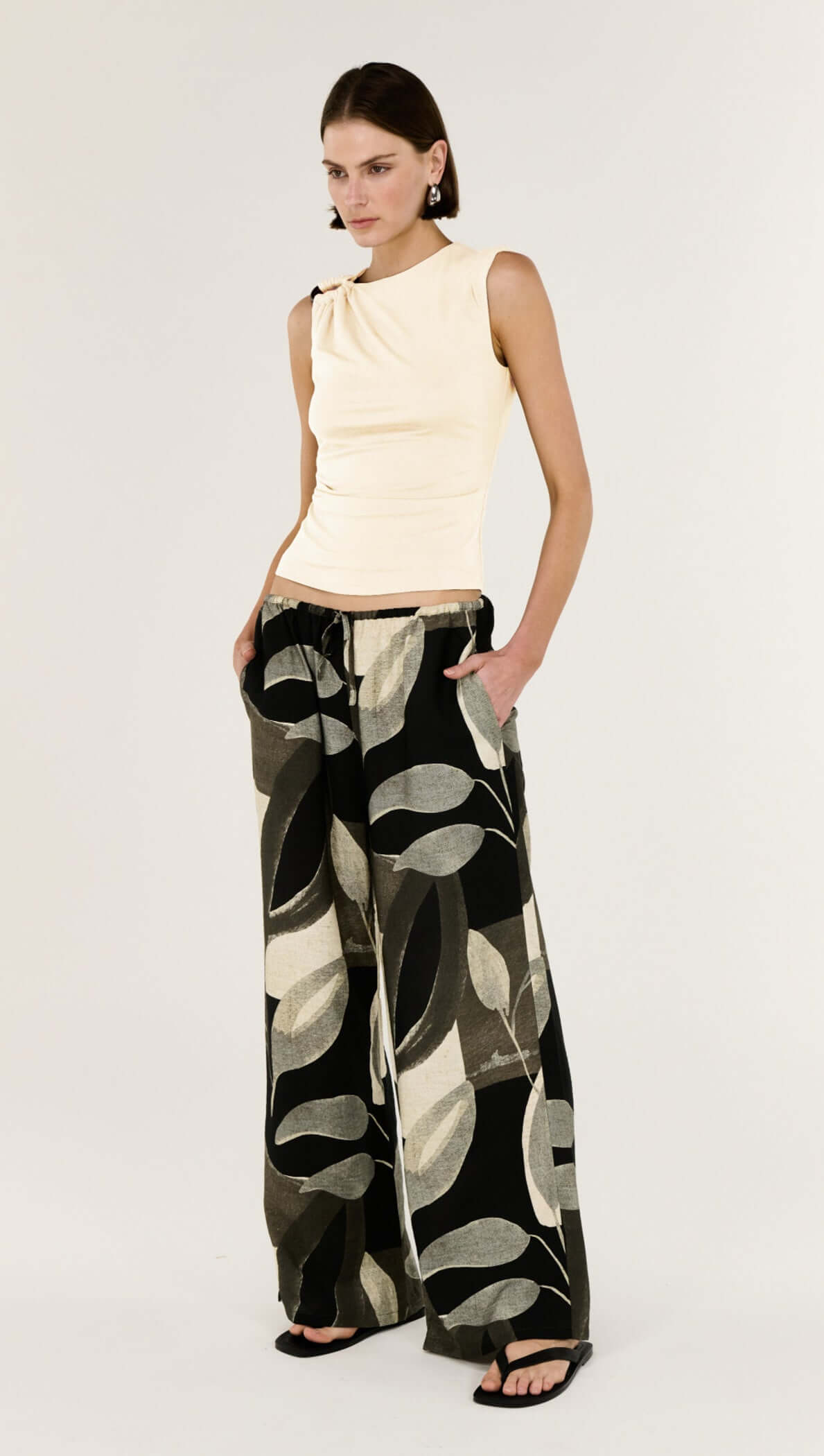 Model showcasing the Cream Ruched Slinky Tank paired with patterned wide-leg pants.