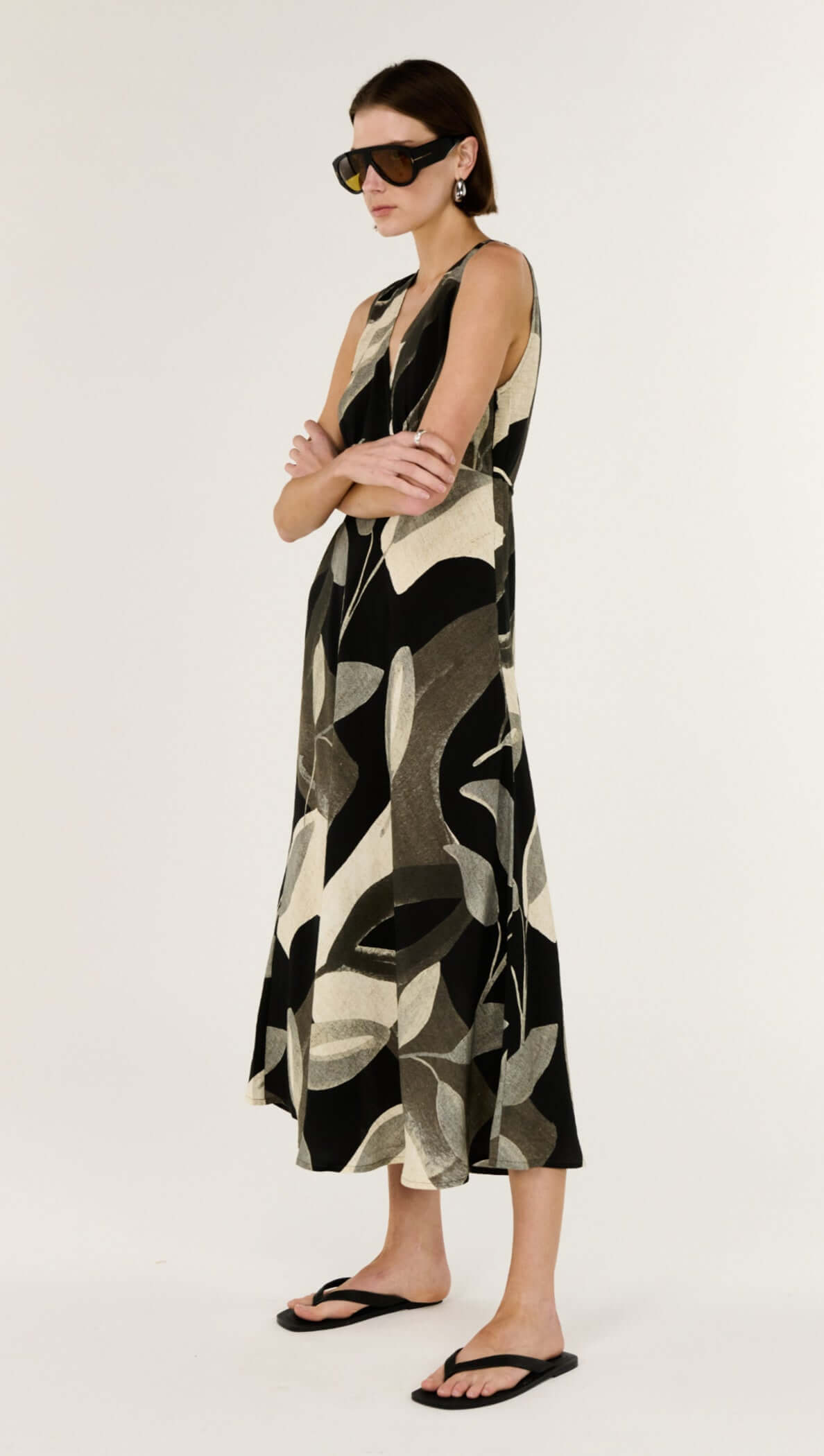 Model wearing the Dark Leaf Bias Midi Dress featuring a V-neckline and fluid silhouette in a leaf print.