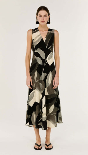 Model wearing the Dark Leaf Bias Midi Dress featuring a V-neckline and fluid silhouette in a leaf print.