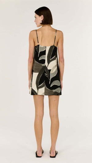 Back view of a woman wearing the Dark Leaf Shift Mini Dress featuring a statement leaf garden print.