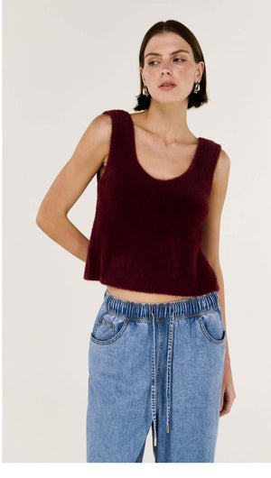 Model wearing a Deep Red Plush Cotton Knit Tank with a scoop neckline, styled with casual denim pants.