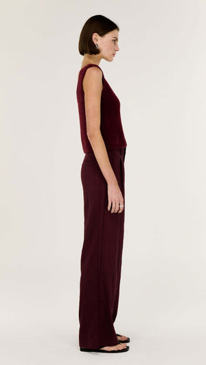 Model showcasing the Deep Red Textured Wide-Leg Pant in a side view, highlighting a high-rise waist and fluid silhouette.