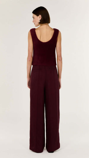 Woman wearing the Deep Red Textured Wide-Leg Pant from the back, showcasing its high-rise waist and fluid silhouette.