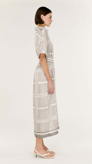 Side view of a model wearing a Geometric Print Button Front Midi Shirt Dress featuring a classic collar and short sleeves.