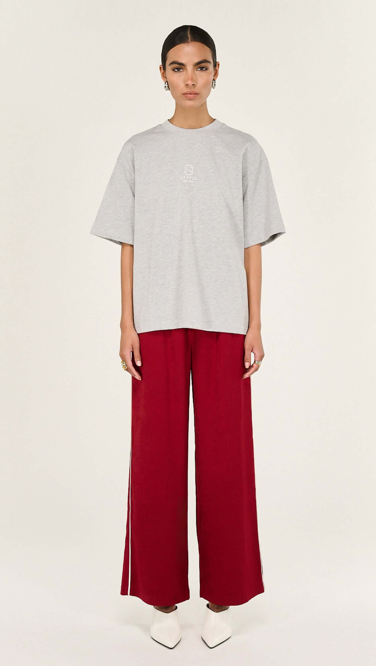 Model wearing Grey Marle Cotton Embroidered Oversized Tee paired with wide red pants, showcasing a relaxed silhouette.