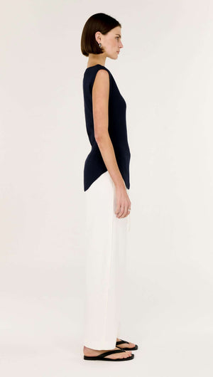 Model showcasing the Navy Boat Neck Knit Top in navy blue, featuring an asymmetrical hem and sleek, body-skimming fit.